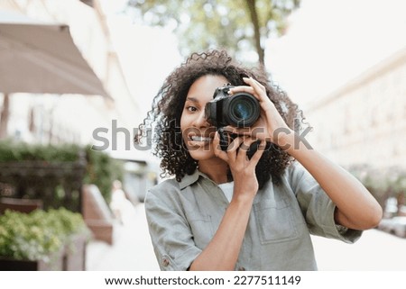 Woman photographer with digital camera taking pictures outdoor Royalty-Free Stock Photo #2277511149