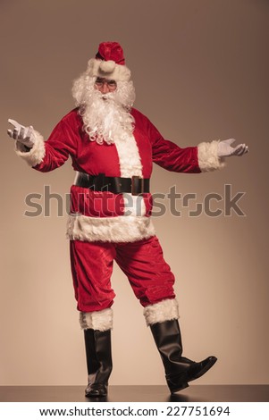 Full length picture of Santa Claus welcoming you, on studio background.
