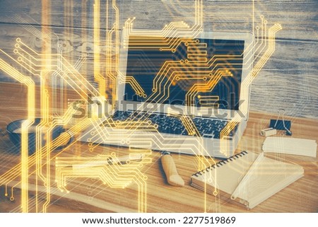 Computer on desktop in office with technology theme hologram. Double exposure. Tech concept.