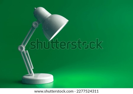 White table lamp on a green background, copy space. Royalty-Free Stock Photo #2277524311