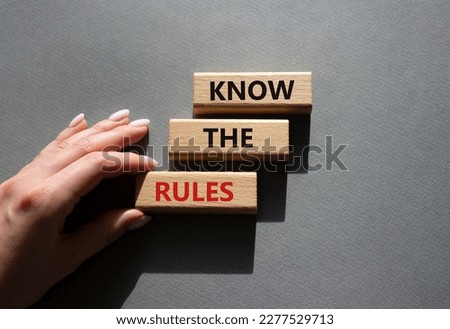 Know the rules symbol. Wooden blocks with words Know the rules. Beautiful grey background. Businessman hand. Business and Know the rules concept. Copy space.