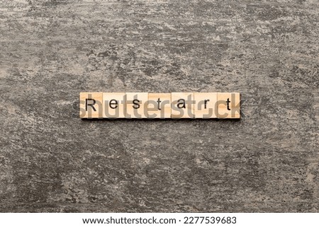 restart word written on wood block. restart text on table, concept.