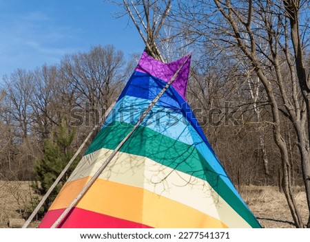 rainbow-coloured tepee set up in the garden, early spring, traditional Indian dwelling

