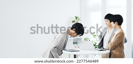 Young man bowing to women in the office. Royalty-Free Stock Photo #2277546489