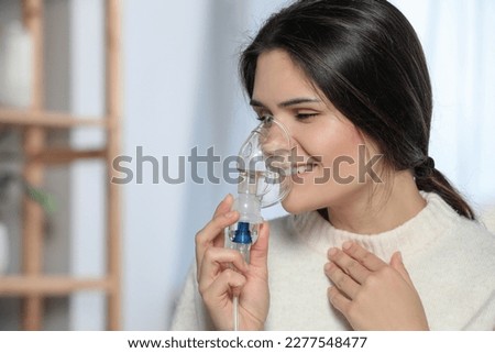 Sick young woman using nebulizer at home, space for text Royalty-Free Stock Photo #2277548477