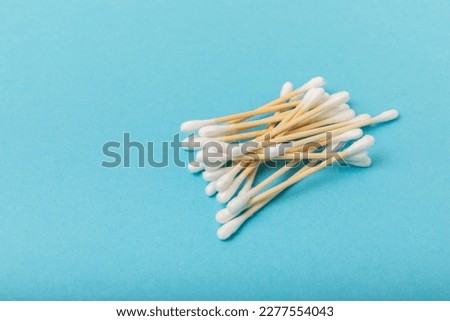 Cotton buds on a blue background.Eco-friendly materials. Wooden, cotton swabs on a white background.Bamboo swabs and cotton flowers.Zero waste, plastic free lifestyle concept.Place for text. Royalty-Free Stock Photo #2277554043