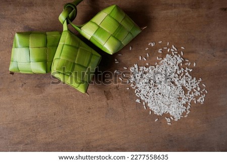Close up view of Ketupat and rice. Indonesian traditional cuisine very popular during Hari Raya Idul Fitri. Ketupat is a natural rice casing made from young coconut leaves for cooking rice Royalty-Free Stock Photo #2277558635
