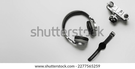 Vintage photo camera, wireless headphones and smart watch on light background with space for text Royalty-Free Stock Photo #2277565259