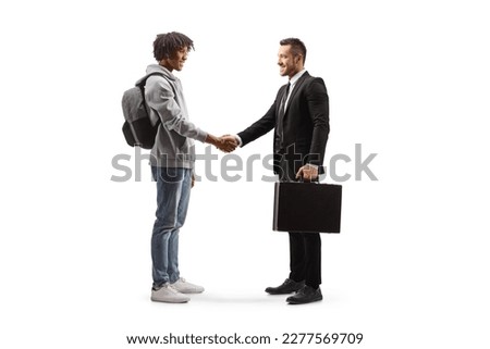 Full length profile shot of an african american young man  shaking hands with a businessman isolated on white background Royalty-Free Stock Photo #2277569709