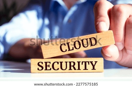 Close up on businessman holding a wooden block with "CLOUD SECURITY" message