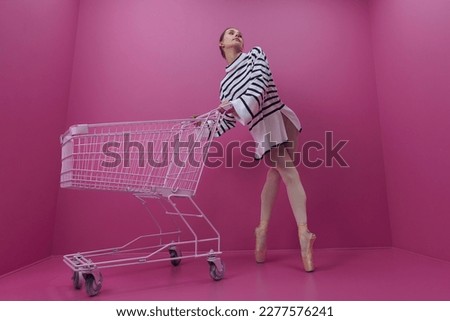 a young ballerina in white tights and a half-skirt poses with a shopping cart from the store