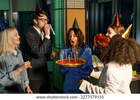 Business people celebrating birthday with party and blow out the candles in the pizza