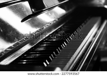 Black and white photo of the keys of an old vintage piano. 