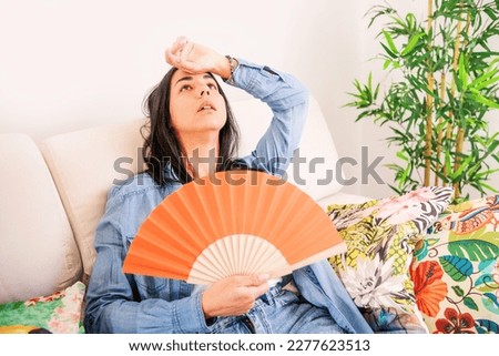 Woman suffering summer heat trying to stay cool and comfortable during heat wave Royalty-Free Stock Photo #2277623513