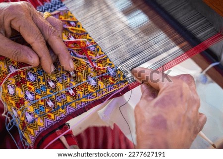 Women hand weave traditional fabrics and textiles technique locally with unique craftsmanship and the famous sarong popular product as a souvenir in Mae Chaem District, Chiang Mai, Northern Thailand. Royalty-Free Stock Photo #2277627191