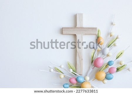 Cross with Easter eggs on a white background with copy space  Royalty-Free Stock Photo #2277633811