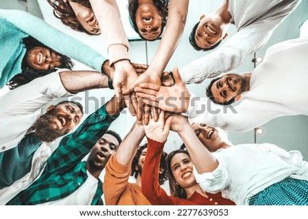 Multicultural group of people stacking hands together - University students putting their hands on top of each other - Human relationship, social, community, startup, teambuilding and college concept Royalty-Free Stock Photo #2277639053
