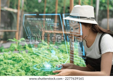 Smart farming technology,business,industry agriculture food concept,young women farmer using interface screens in greenhouse,monitor plant growth agricultural products,with artificial intelligence 