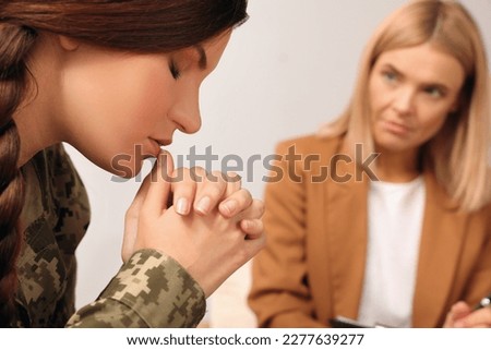 Psychologist working with military officer indoors, closeup