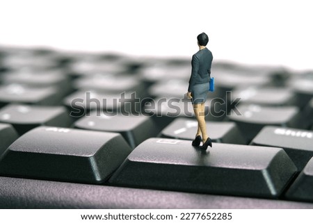 Miniature people toy figure photography. Typing job concept. A businesswoman standing above black keyboard. Isolated on white background. Image photo