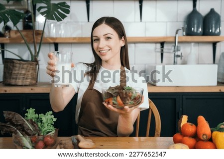 woman using laptop computer searching and learning for cooking healthy food from fresh vegetables and fruits in kitchen room.