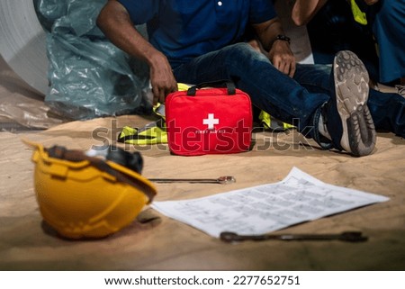 Emergency staff in safety suit use first aid kit to help a man who has an accident in factory workplace, First aid training in industrial company. Royalty-Free Stock Photo #2277652751