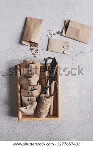 spring preparations for seeding. Top view of handmade craft paper bags , with seeds on grey background. Seeds organization. Royalty-Free Stock Photo #2277657433