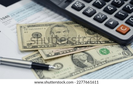Tax season concept. Tax planning and consulting service business. Pen, calculator, dollar banknote, and income tax return form for filling and calculating tax payments. Money and financial concept.  Royalty-Free Stock Photo #2277661611