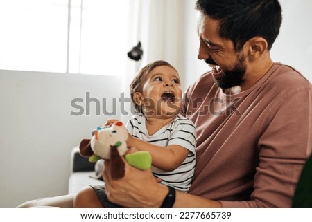 Father and baby son with teddy bear at home. Candid moment of father and son together. Royalty-Free Stock Photo #2277665739