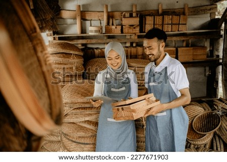 asian muslim woman and her partner checking bamboo product at their traditional workshop Royalty-Free Stock Photo #2277671903