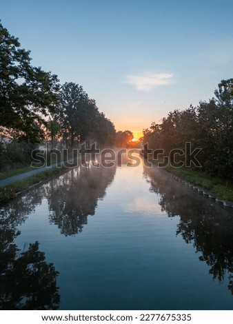 Aerial view of a colorful dramatic sunrise sky over a canal in Belgium. Canals with water for transport, agriculture. Fields and meadows. Landscape. High quality photo. High quality photo