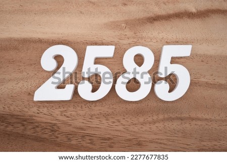 White number 2585 on a brown and light brown wooden background.
