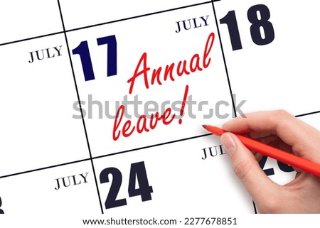 17th day of July. Hand writing the text ANNUAL LEAVE and drawing the sun on the calendar date July 17. Save the date. Time for the holidays. vacation calendar.  Summer month, day of the year. Royalty-Free Stock Photo #2277678851