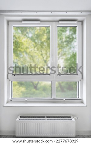 new double glazed pvc window with modern folded pleated blind jalousie in living room after renovation, blurred green trees view background Royalty-Free Stock Photo #2277678929