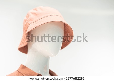 A mannequin with cap or hat. wearing unusual hat.