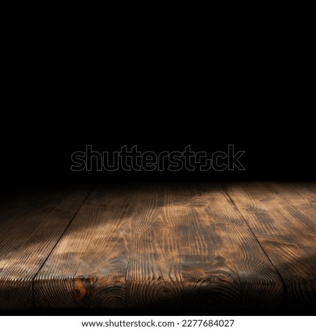 Wooden board with shadows and black wall background. Free space for your decoration. 
