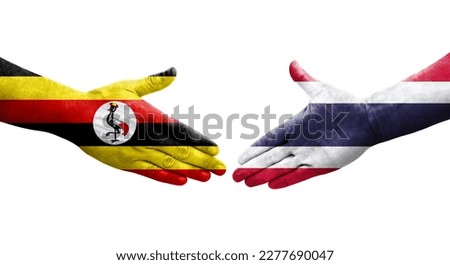 Handshake between Thailand and Uganda flags painted on hands, isolated transparent image.