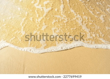 Close-up of a beach with a calm transparent wave. Romantic sea coast with golden sand. Royalty-Free Stock Photo #2277699419