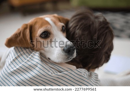 boy and faithful beagle sharing a loving embrace in a charming snapshot. Picture perfect moment of a dog lover cuddling with his furry companion, radiating happiness