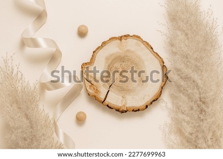 Wooden aesthetic podium with pampas grass and ribbon, beige tone. Gentle background for natural product presentation, bohemian style, top view, flat lay