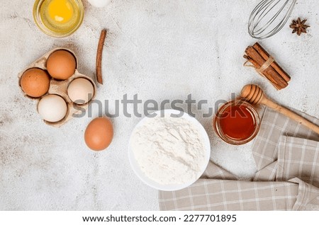 Baking homemade cookies on gray kitchen worktop with ingredients -flour, eggs,  sugar and  cinnamon. culinary background, copy space, overhead view