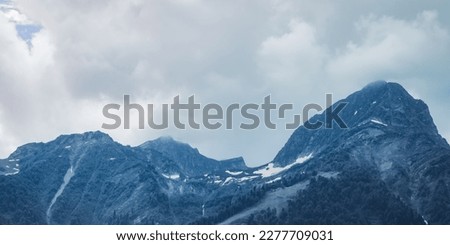 Mountain landscape. Snowy peak. Fog and aerial perspective.