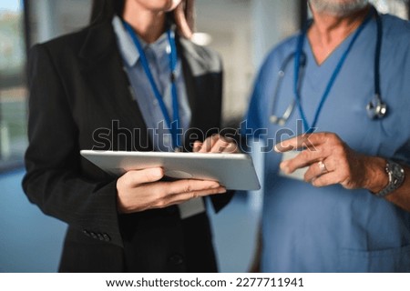Close-up of young pharmaceutic seller explaining something to doctor in hospital. Royalty-Free Stock Photo #2277711941