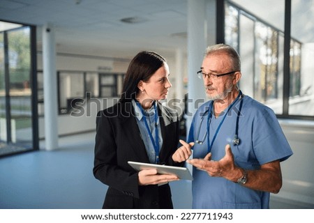Young pharmaceutic seller explaining something to doctor in hospital. Royalty-Free Stock Photo #2277711943