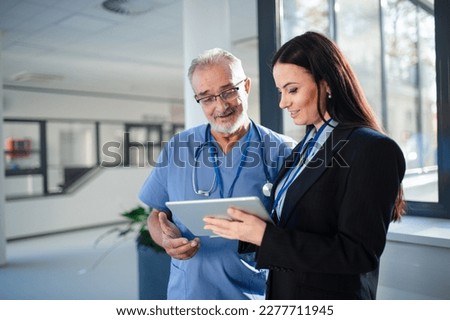 Young pharmaceutic seller explaining something to doctor in hospital. Royalty-Free Stock Photo #2277711945