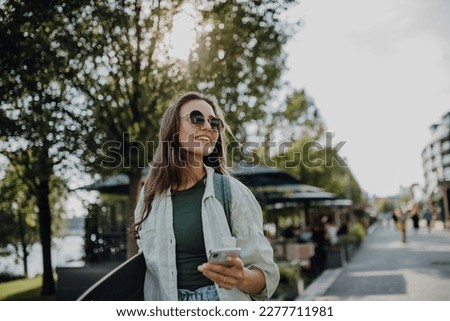 Portrait of young happy woman outdoor with skateboard. Youth culture and commuting concept. Royalty-Free Stock Photo #2277711981