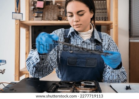 Repairman holding the laptop case for its repair and maintenance. Repair and maintenance of laptops. Selective focus. Close up