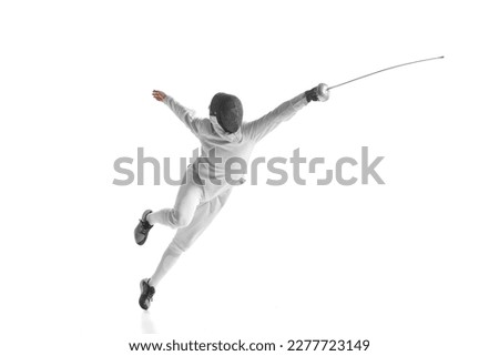 Professional male fencer in fencing costume training with sword isolated on white studio background. Concept of sport, competition, professional skills, achievements. Fencing technique Royalty-Free Stock Photo #2277723149
