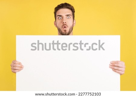 Surprised caucasian man hair holding a blank panel