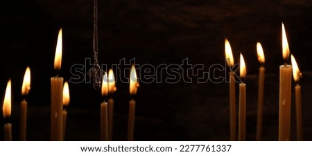 Burning Church candles and Orthodox cross on dark abstract background. Religious, mourning concept. We Remember, mourn. symbol of Lent, Easter, Faith in God, Prayer. banner. copy space